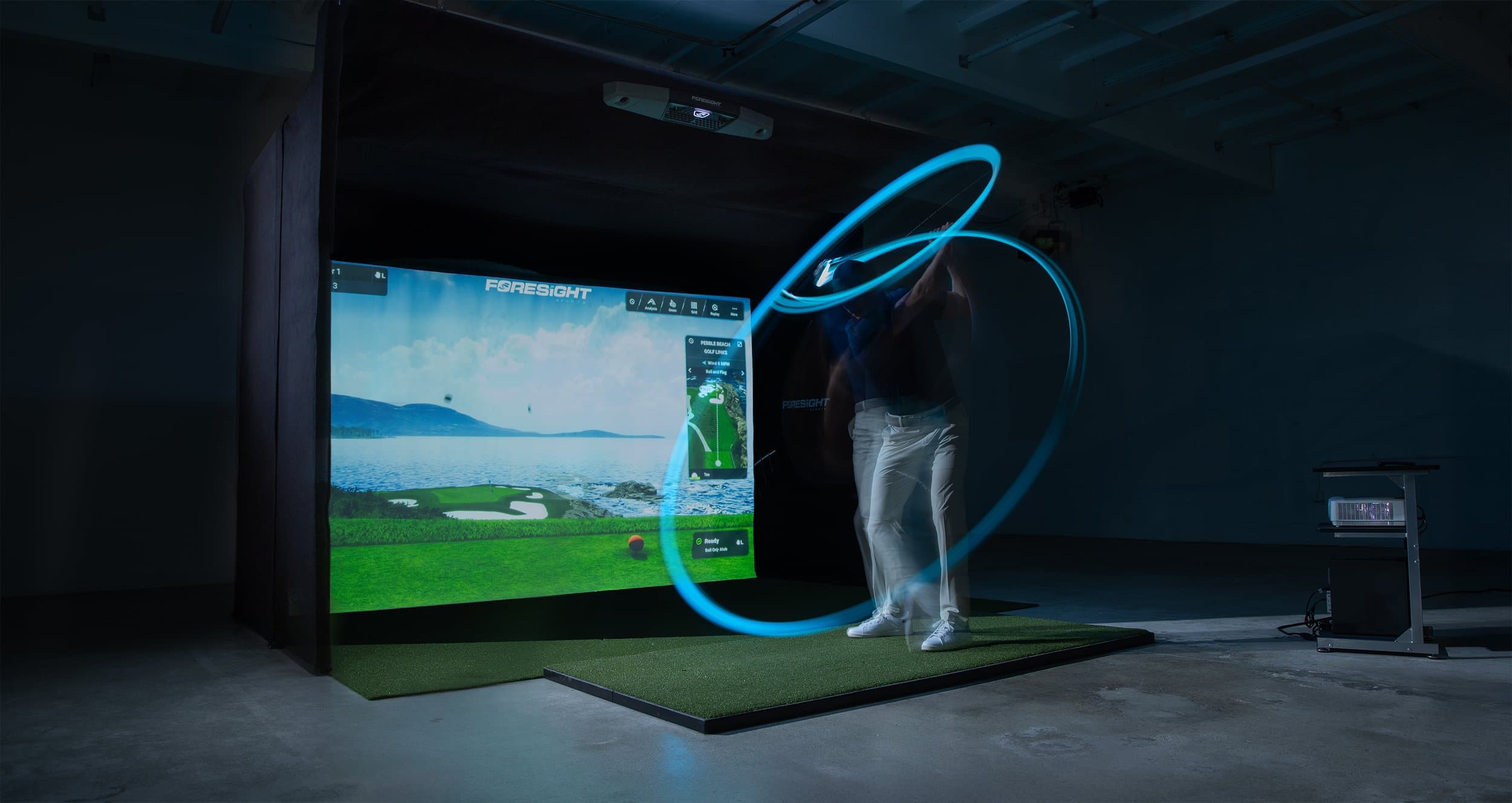 A player mid-swing in a darkened Foresight bay, the swing traced as a light trail
